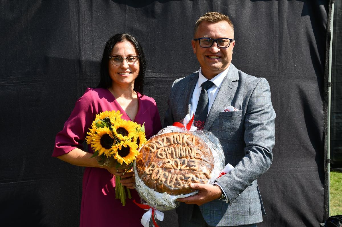Wójt gminy Oleśnica Marcin Kasina wraz z żoną Agnieszką Kasiną trzymają chleb dożynkowy z napisem Dożynki Gminy 2023 Boguszyce